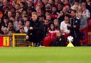 A crouching Eddie Howe watches on from the touchline during Newcastle's defeat to Man Utd