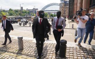 Daniel Graham (centre) and Adam Carruthers (right) leaving Newcastle Upon Tyne Magistrates' Court after appearing in connection with the felling of the Sycamore Gap tree.