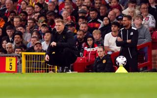A crouching Eddie Howe watches on from the touchline during Newcastle's defeat to Man Utd