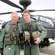 King Charles and Prince Harry in front of an Apache helicopter