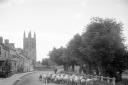 7. A shepherd herding a flock of sheep along the street in Helmsley, with All Saints Church in the background. Date unknown. (Historic England Archive)