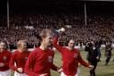 TRIUMPH: Ray Wilson, holding the trophy, celebrates with George Cohen, Bobby Moore and Jack Charlton Picture: PA