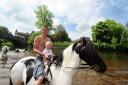 GOLDEN TOT: 18-month-old David Briganti, from Gateshead, with Jeff Nesham, 16, on a horse in the River Eden at the Appleby Horse Fair