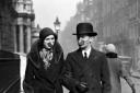 A couple wear masks as they go for a stroll at the time of the 1918 Spanish Flu epidemic