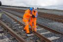 (From left) Robert Clayton, test manager, Hitachi Rail Europe, and Simon Turner, project manager at Story Contracting, fitting the final pandrol clip to connect the Hitachi train factory at Newton Aycliffe to the rail network.
