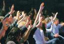 HANDS RAISED: Members of the congregation at the Xcel Church, in the Xcel Centre, Newton Aycliffe