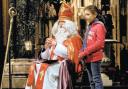 LITTLE HELPER: St Nicholas assisted by Emily Williamson from the Chorister School