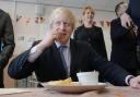 BOX OFFICE: Mayor of London Boris Johnson samples a local delicacy as he tries eating a parmo during a visit to Conyers School in Yarm, North Yorkshire