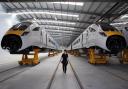 A worker at Hitachi Rail Europe's Newton Aycliffe plant walks the factory floor surrounded by examples of its rolling stock. Picture: CHRIS BOOTH