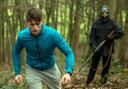 Joe Tate [NED PORTEOUS] jogs through the woods and comes face-to-face with a man in a mask.