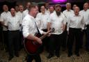 Mike McGrother leads the Infant Hercules male voice choir in song Picture: CHRIS BOOTH
