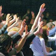 HANDS RAISED: Members of the congregation at the Xcel Church, in the Xcel Centre, Newton Aycliffe