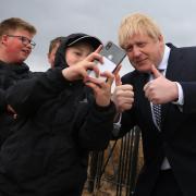Prime Minister Boris Johnson (right) poses for a 'selfie' photograph as he meets members of the public while campaigning on behalf of Conservative Party candidate Jill Mortimer (unseen) in Hartlepool, in the north-east of England ahead of the