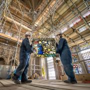 York Glaziers Trust employees Kieran Muir (left) and Emily Price (right) remove a stained glass window panel at the start of a new five year, Â£5m project to conserve York Minster's South East Transept and its medieval St Cuthbert Window.