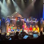 Joseph, played by Scott Edwards, with the narrator in black, Karen Davison, surrounded by the cast of Joseph at the Witham Hall, Barnard Castle
