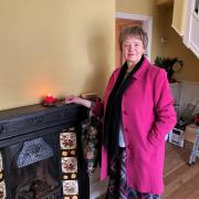 Joan Lawrence lights a a candle inside Claudia's empty house