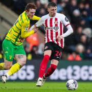 Dan Neil holds off Josh Sargent during Sunderland's defeat at Norwich