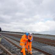(From left) Robert Clayton, test manager, Hitachi Rail Europe, and Simon Turner, project manager at Story Contracting, fitting the final pandrol clip to connect the Hitachi train factory at Newton Aycliffe to the rail network.