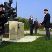 Ken Lodge lays a wreath at the Green Howards monument in Crepon.