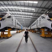A worker at Hitachi Rail Europe's Newton Aycliffe plant walks the factory floor surrounded by examples of its rolling stock. Picture: CHRIS BOOTH