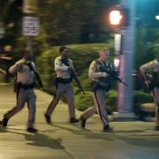 RESPONSE: Police run to cover at the scene of the shooting near the Mandalay Bay resort and casino on the Las Vegas Strip on October 1 in which 58 people died Picture: AP / JOHN LOCHER