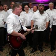 Mike McGrother leads the Infant Hercules male voice choir in song Picture: CHRIS BOOTH