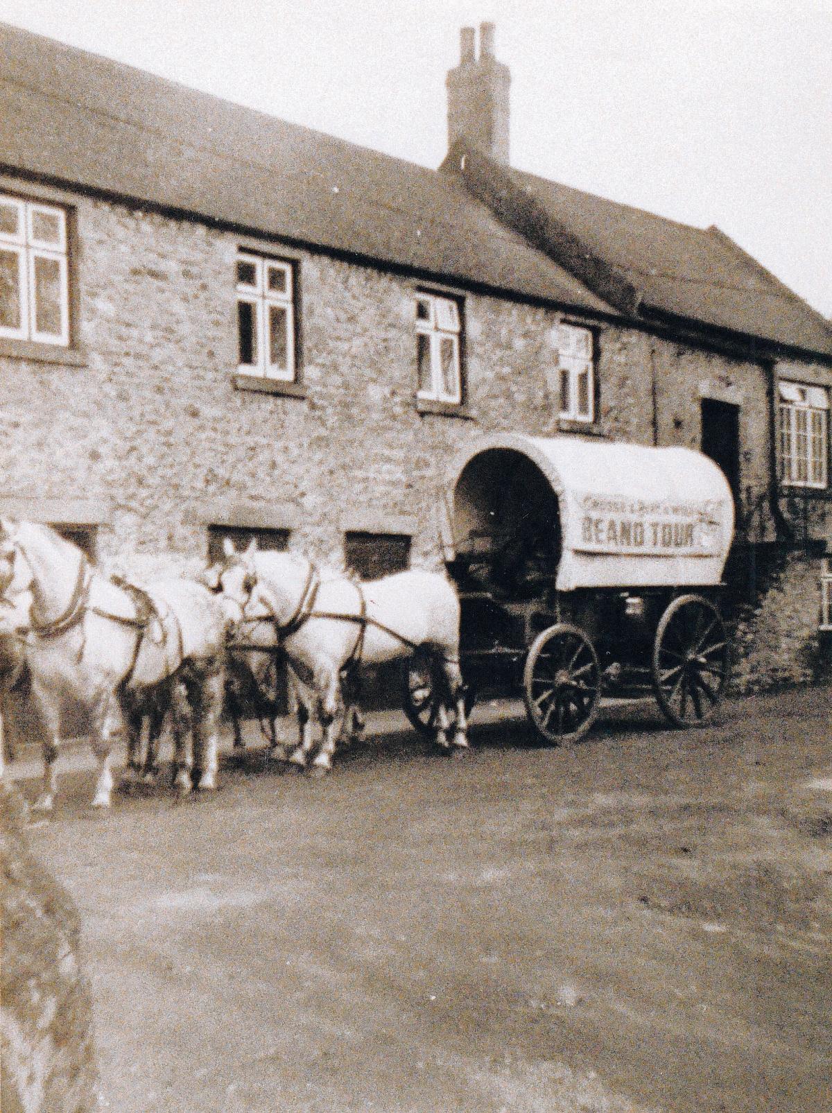 An unusual sight in a British village, a U.S.-style covered
wagon and accompanying horses. The wagon, accompanied by fake cowboys, was part of a promotional campaign for baked beans: The Crosse and Blackwell Beano Tour