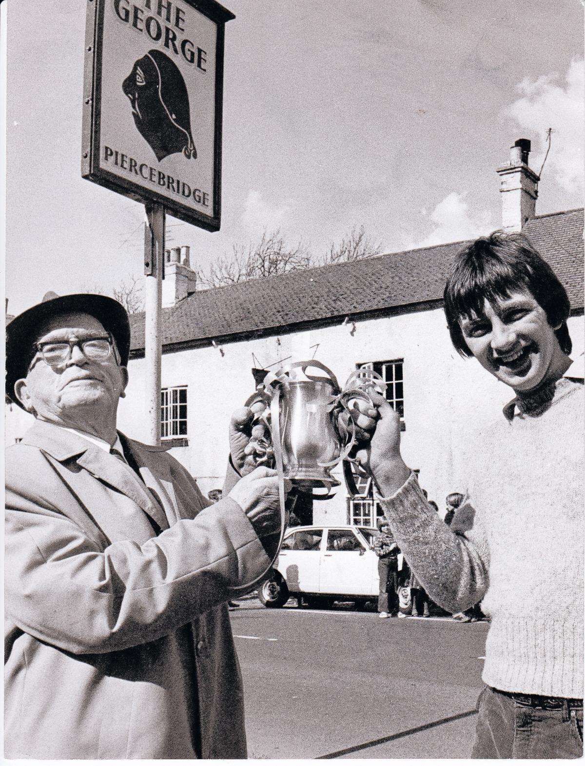 The 84-year-old Gainford businessman Henry Walton hands over the trophy to the 1980 winner, Nicky Longstaff, outside The George Hotel. Henry Walton gave his name to the Easter Monday event, but it no longer appears to take place