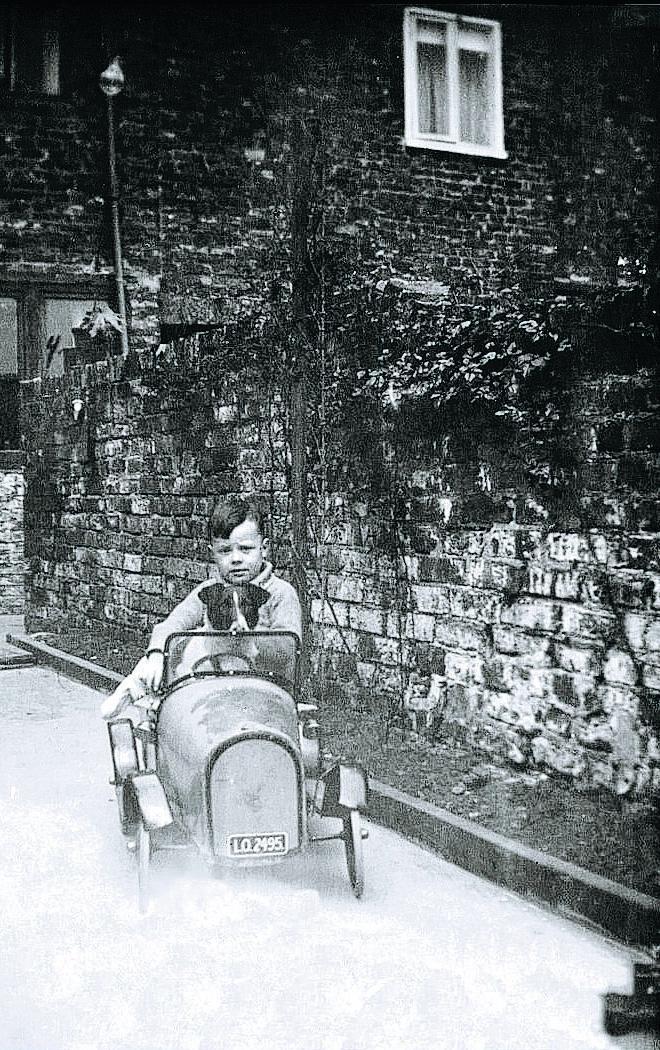 BLACK MARKET: Tommy Pallister, with his dog and his pedal car, behind Bestwicks’ bakery, which was run by his aunt and uncle, Annie and Arthur Bestwick.