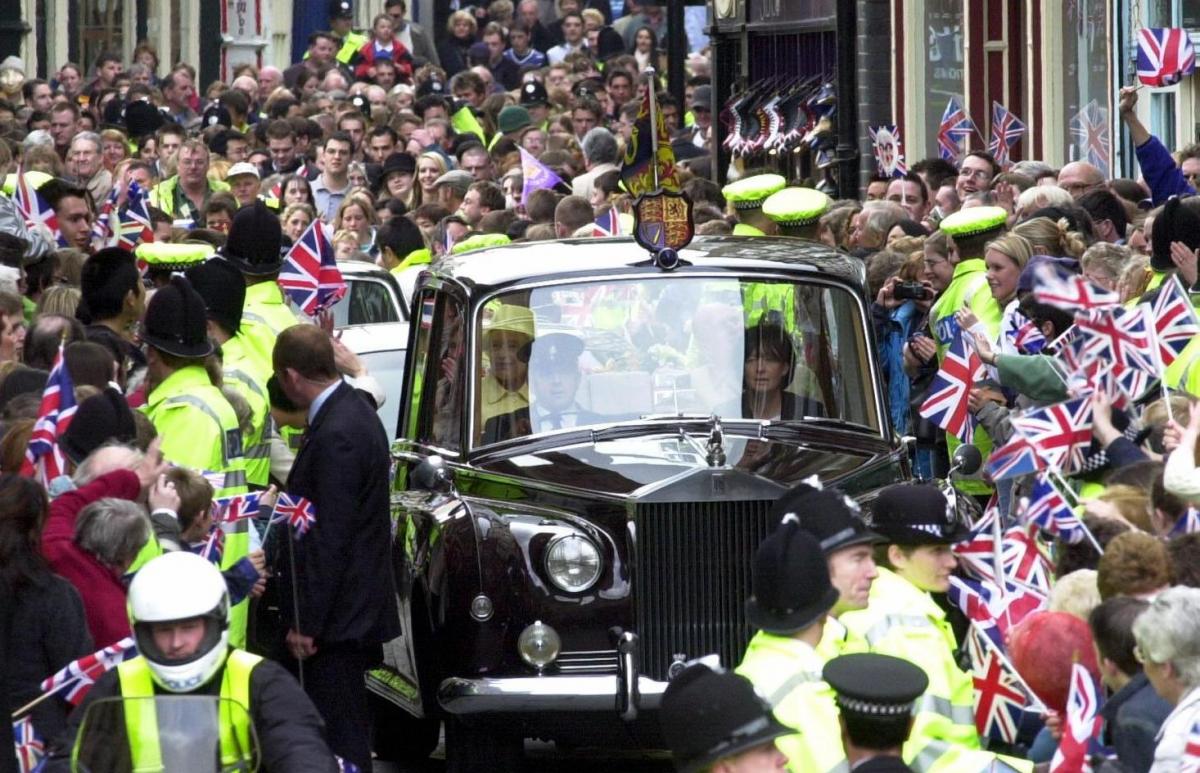 The Queen waves to cheering  wellwishers as she drives through the narrow streets of Durham City on the second day of her jubilee visit to the region