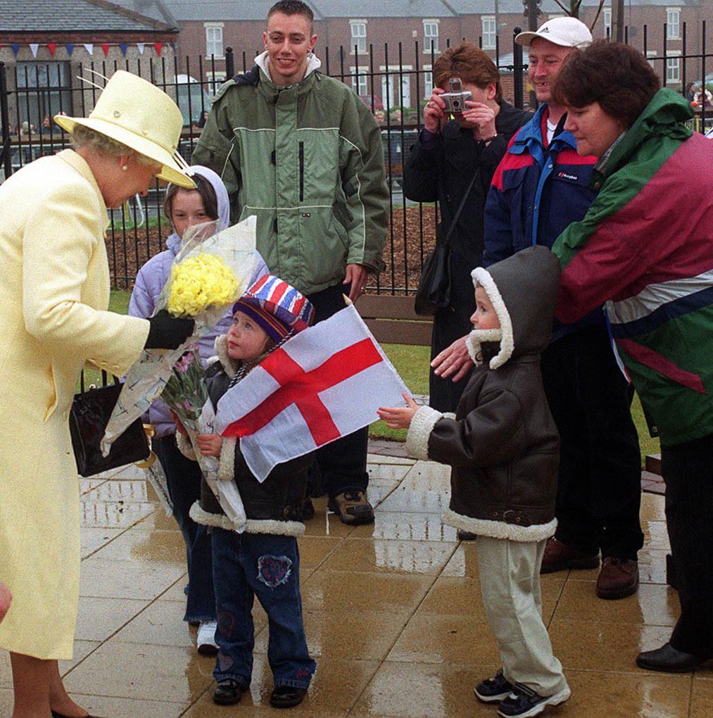 Two children present flowers to the Queen during her visit to Easington during her Golden Jubilee tour of the region