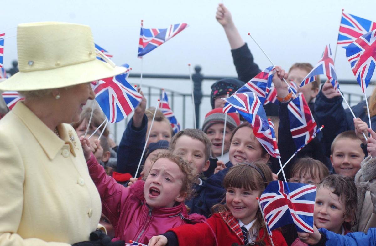 Children in Easington cheer the Queen on her visit during her golden Jubilee tour of the region