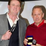 Pools Legend John McGovern receives his medal from Goffy during his Hartlepool tribute event.