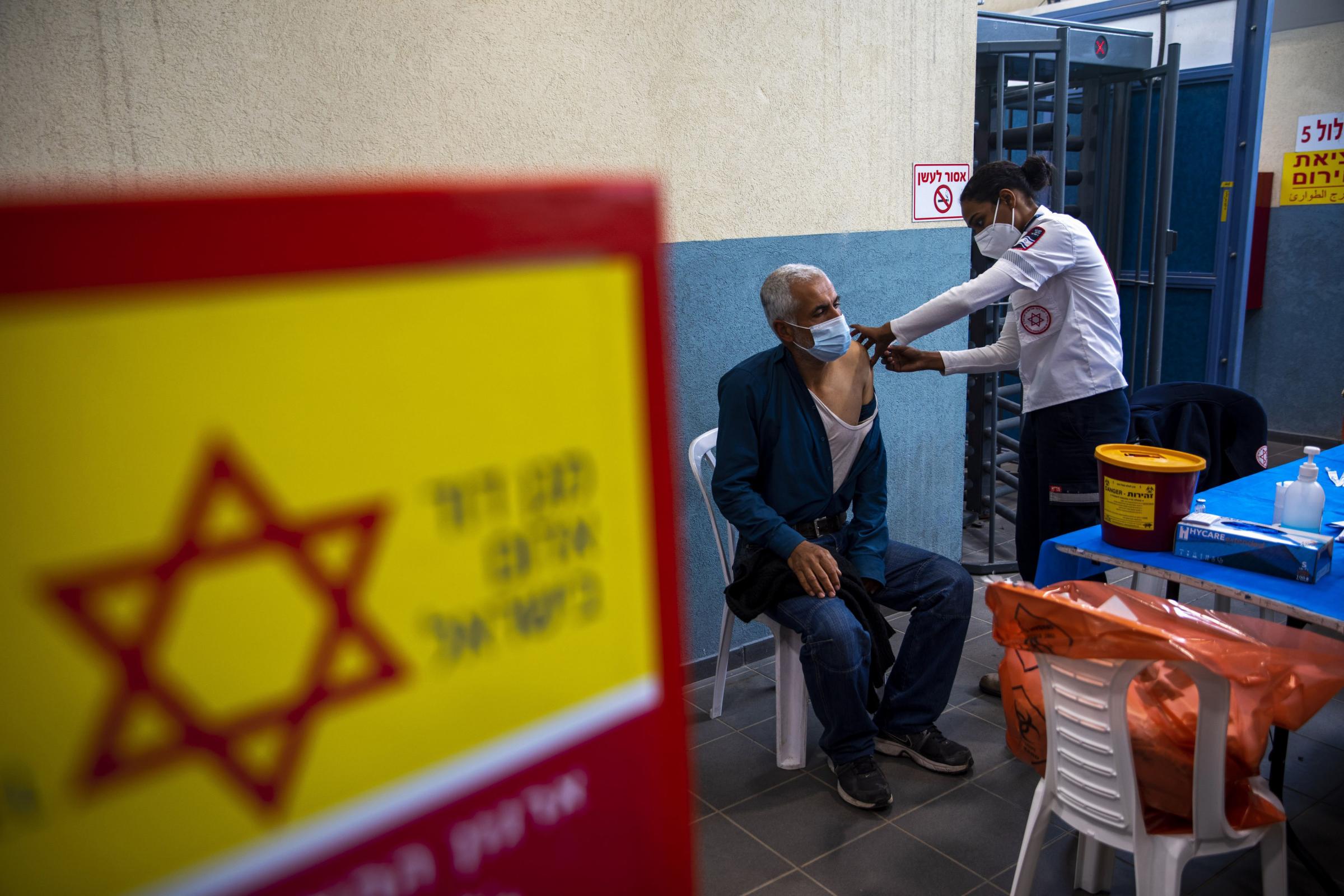 A Palestinian labourer who works in Israel receives his first dose of the Moderna Covid-19 vaccine at a coronavirus vaccination center set up at the Meitar checkpoint crossing between Israel and the West Bank, south of the West Bank town of Hebron