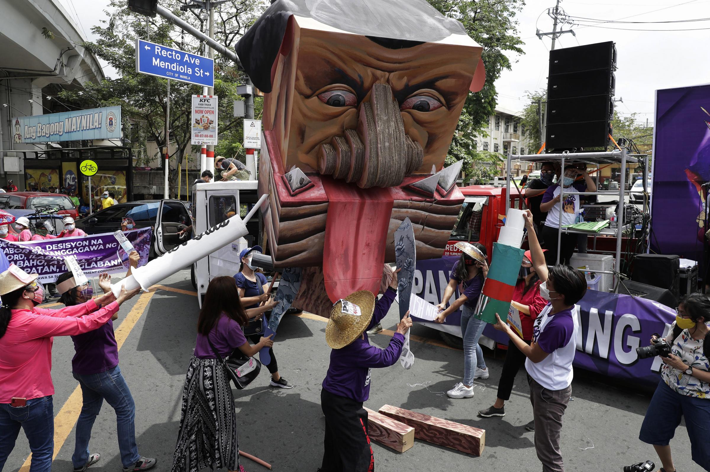 Women activists destroy an effigy of Philippine President Rodrigo Duterte during a rally near the Malacanang presidential palace to mark International Women’s Day Picture: AARON FAVILA/AP