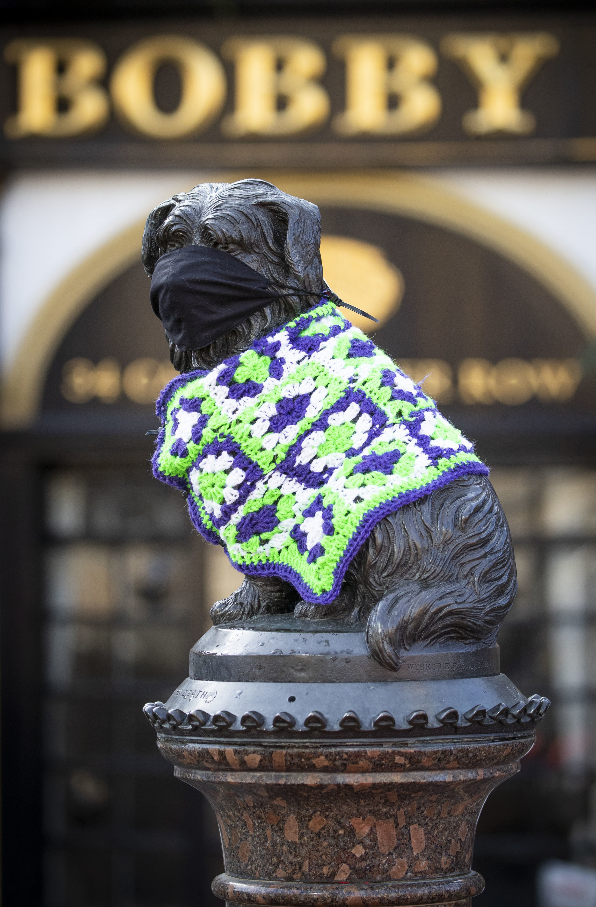 The statue of Greyfriars Bobby, in Edinburgh’s Old Town, wears a protective face mask and knitted coat as lockdown measures for mainland Scotland continue Picture: JANE BARLOW/PA