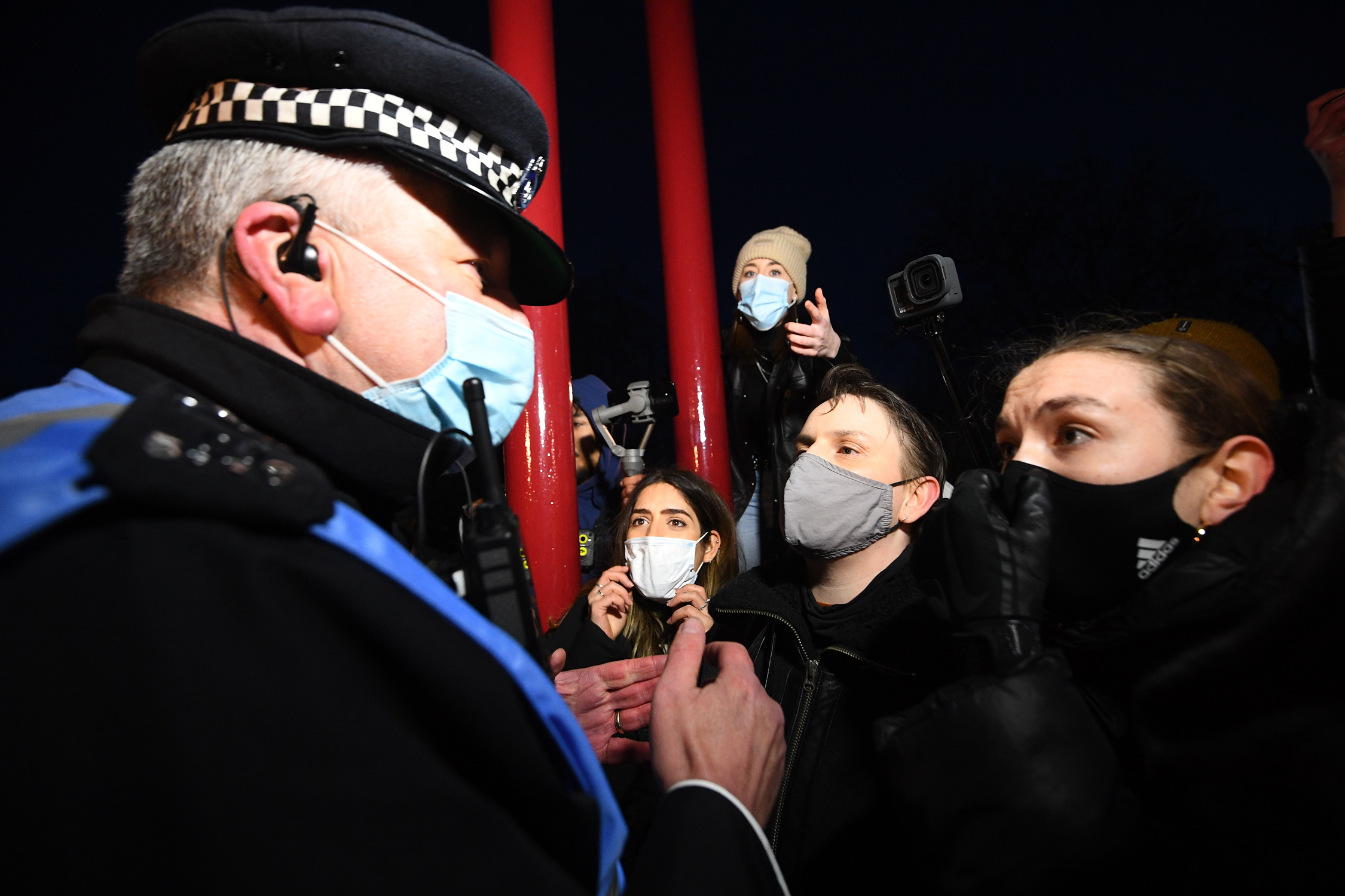 People talk to police as they gather at the band stand in Clapham Common, London, after the Reclaim These Streets vigil for Sarah Everard was officially cancelled. Serving police constable Wayne Couzens, 48, has appeared in court charged with kidnapping