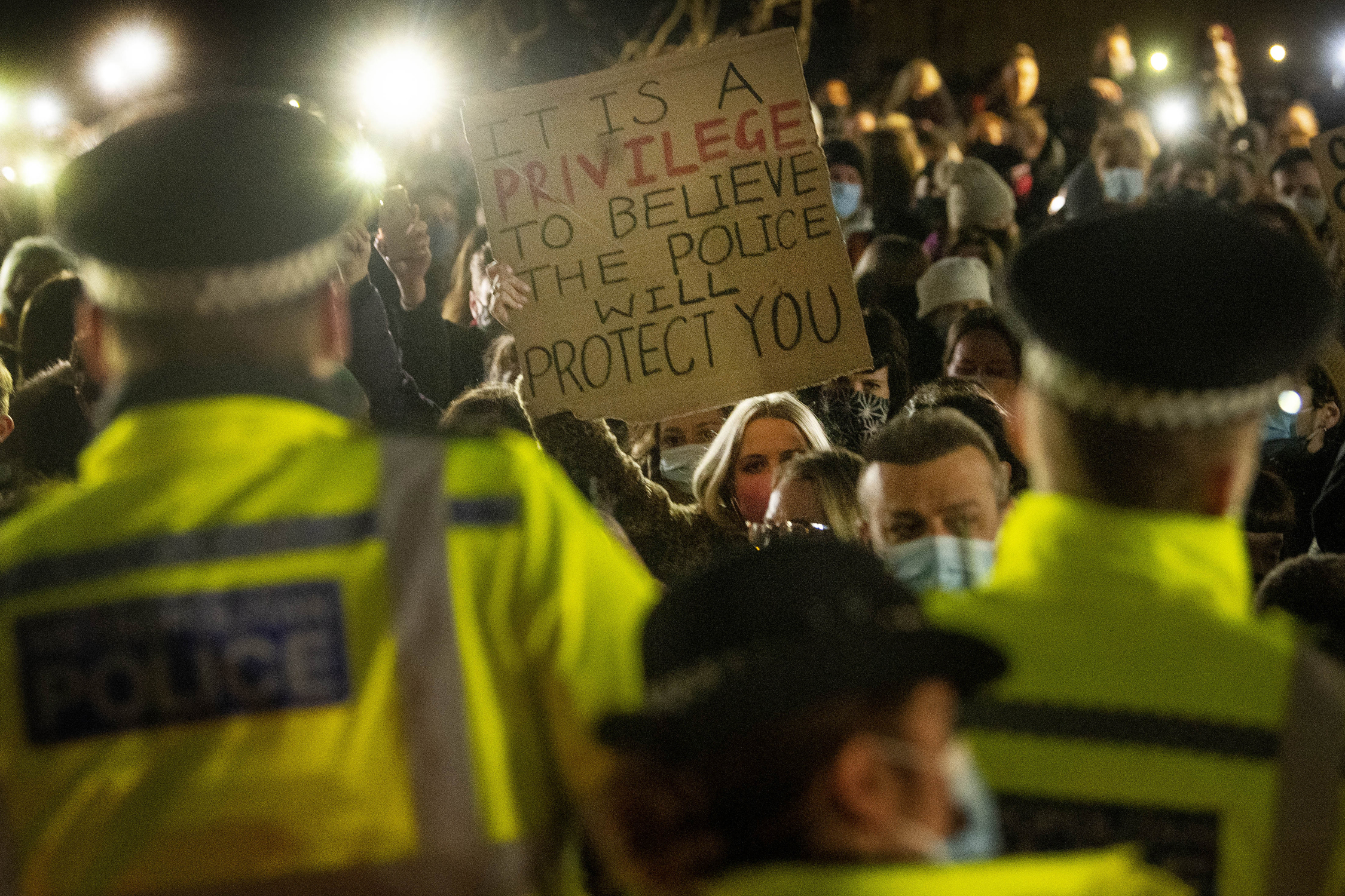 A woman holds up a placard as people gather in Clapham Common, London, after the Reclaim These Streets vigil for Sarah Everard was officially cancelled. Serving police constable Wayne Couzens, 48, has appeared in court charged with kidnapping and killing