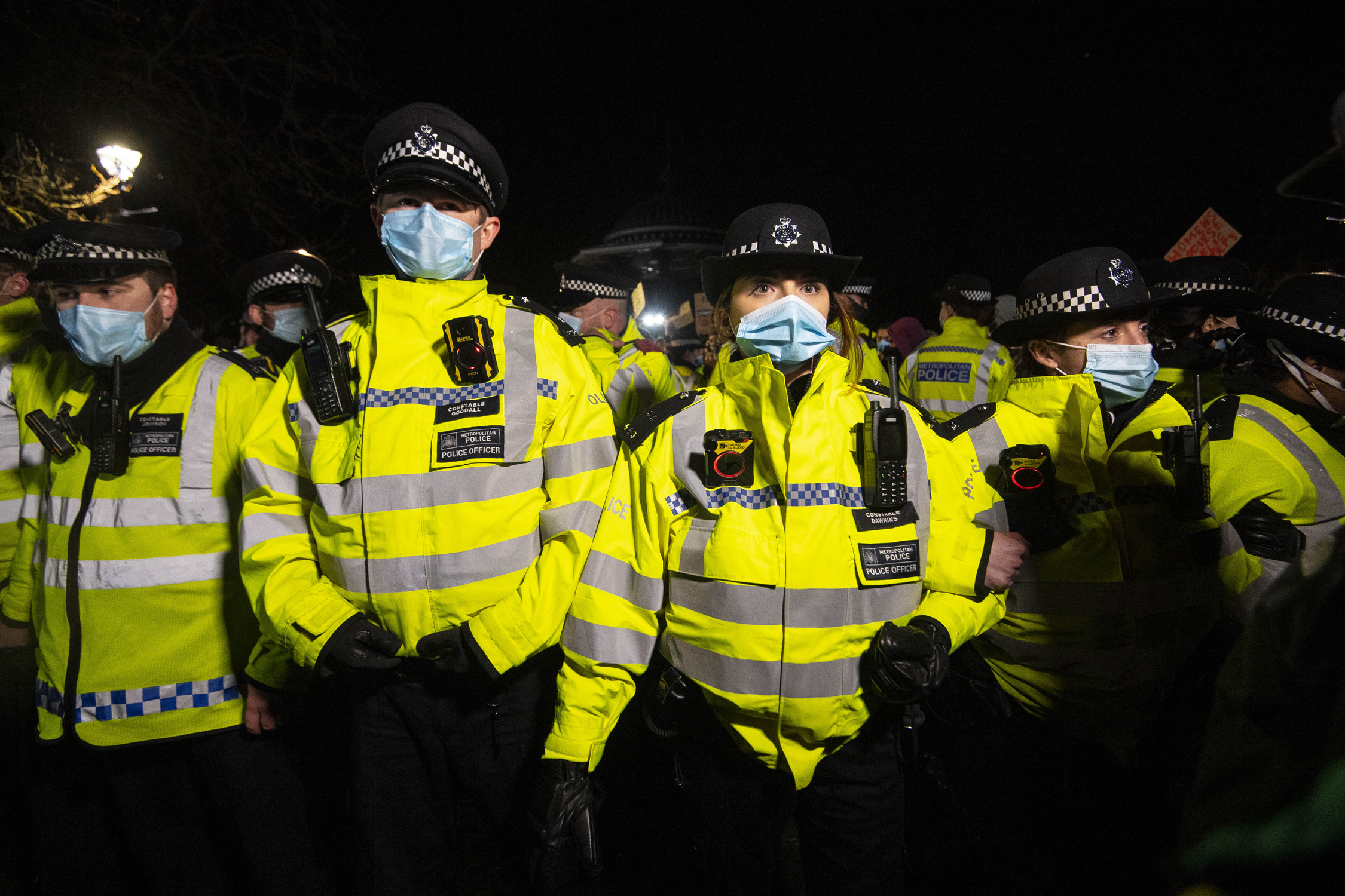 Police officers form a line as people gather in Clapham Common, London, after the Reclaim These Streets vigil for Sarah Everard was officially cancelled. Serving police constable Wayne Couzens, 48, has appeared in court charged with kidnapping and