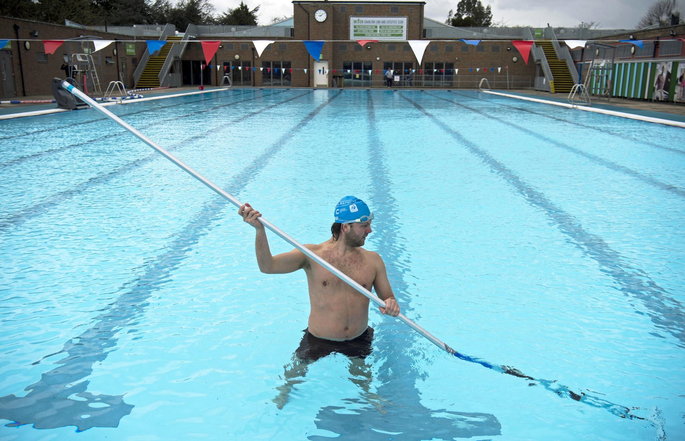 A member of staff cleans the bottom of the pool during pre-opening preparation and cleaning of Charlton Lido, south London, following its closure due to lockdown Picture: MARTIN RICKETT/PA