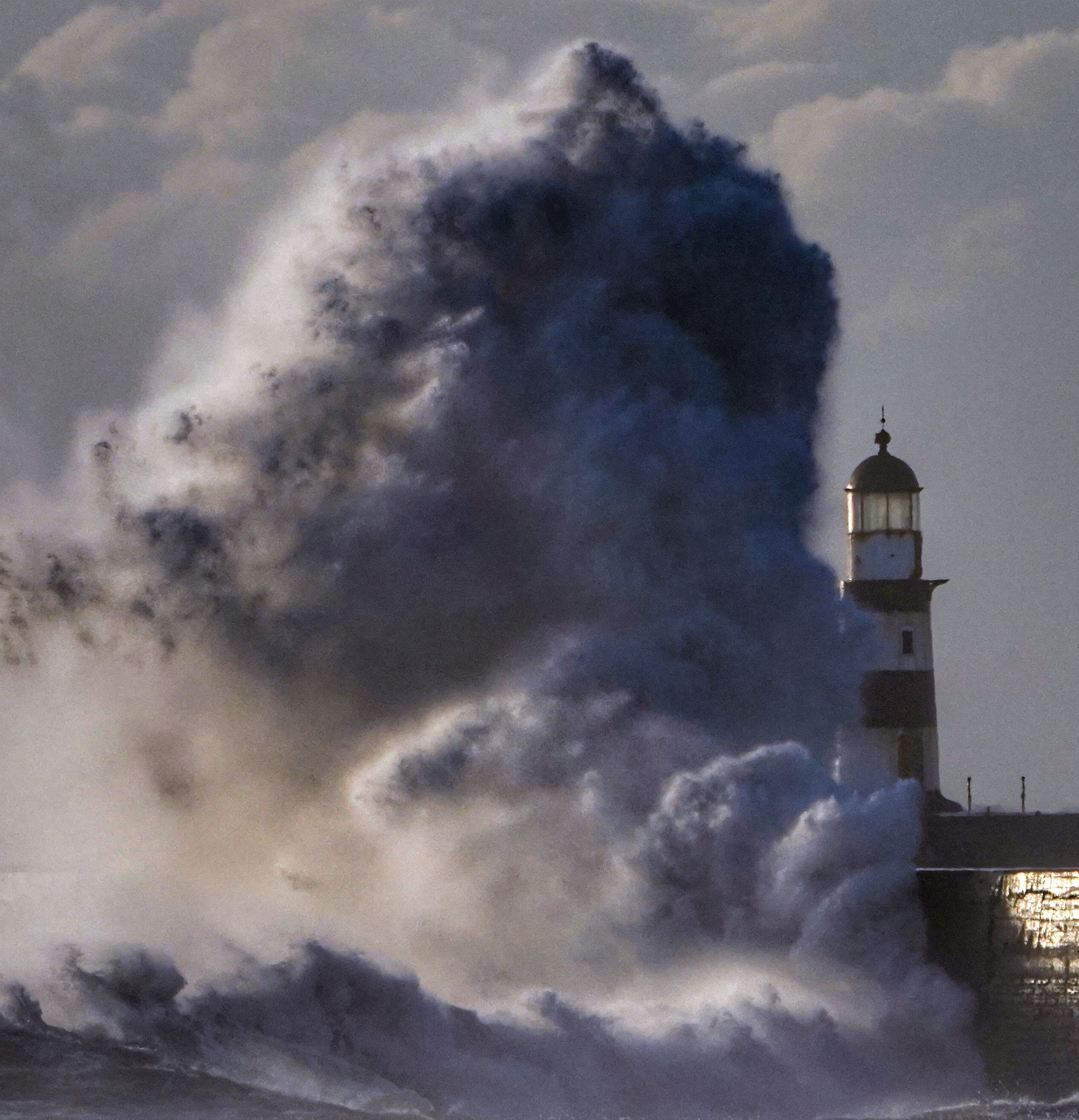 Waves crash over the walls next to Seaham Lighthouse in Durham Picture: OWEN HUMPHREYS/PA.