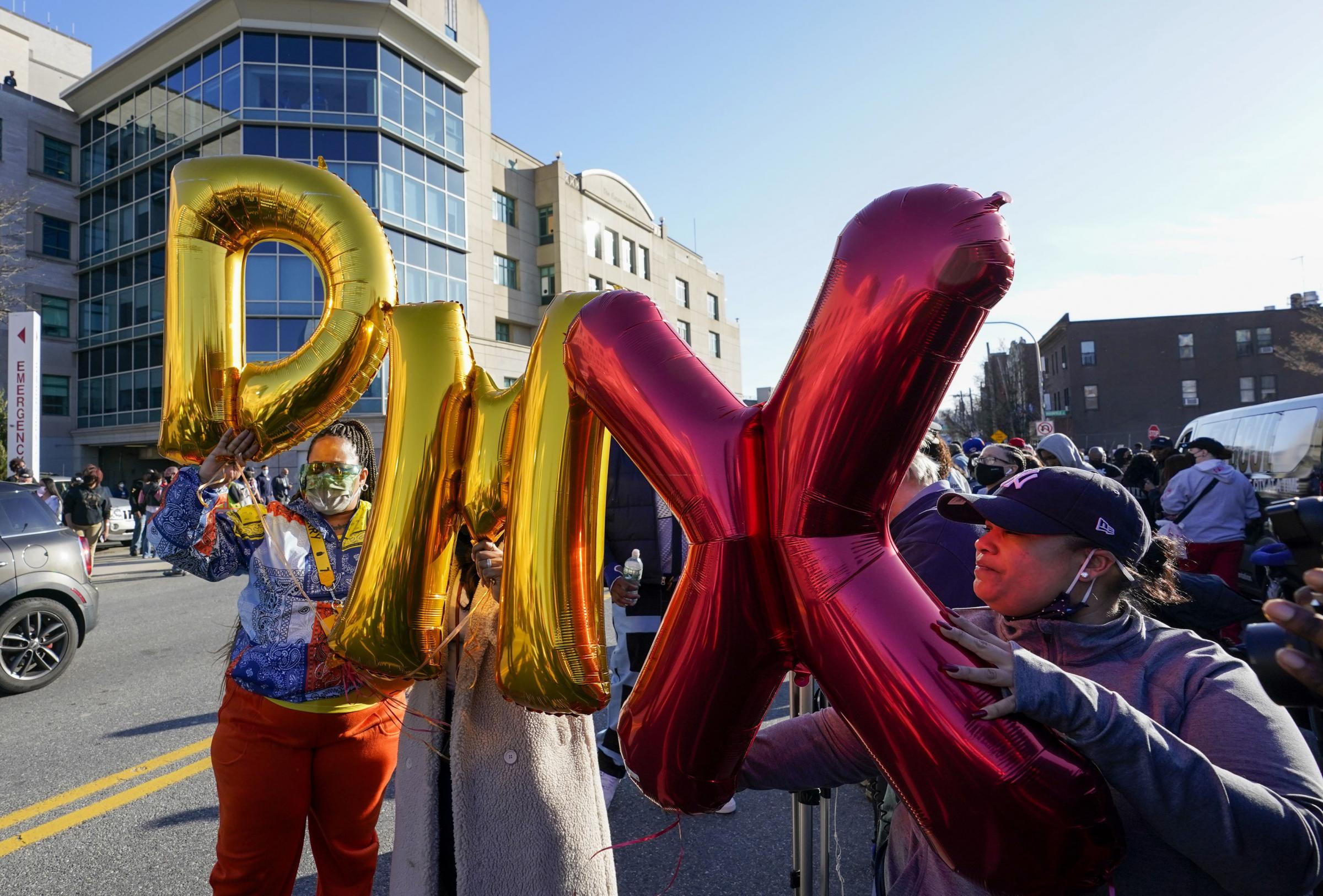Fans hold up DMX balloons during a prayer vigil outside of White Plains Hospital, in White Plains, N.Y. Supporters and family of the rapper DMX have chanted his name and offered up prayers outside the hospital where he remains on life support