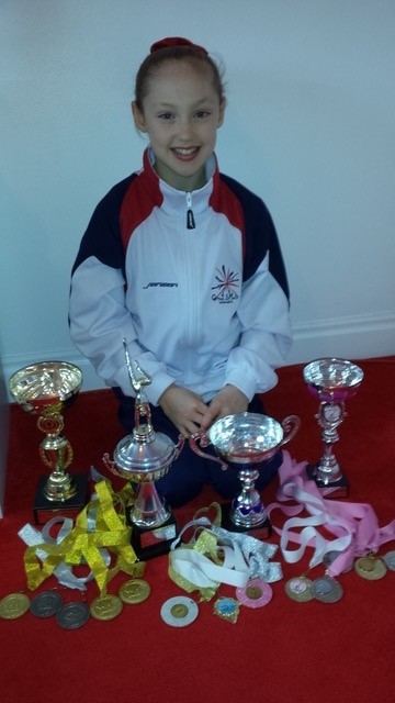 Mia Scott with some of her early medals and trophies