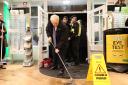 Prime Minister Boris Johnson helps with the clean up at an opticians as he visits Matlock on November 8