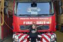 Olivia Ramsay, aged 7, stands in front of one of the team's fire engines.