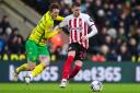Dan Neil holds off Josh Sargent during Sunderland's defeat at Norwich