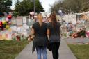 Sara Smith, left, and her daughter Karina Smith visit a makeshift memorial outside the Marjory Stoneman Douglas High School, where 17 students and faculty were killed in a mass shooting. Picture: AP