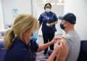 A member of the public receives the Pfizer COVID-19 vaccination at a vaccination site in Liberty Shopping Centre, Romford, east London, as the Government accelerates the Covid booster programme to help slow down the spread of the new Omicron variant.