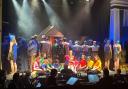 Joseph, played by Scott Edwards, with the narrator in black, Karen Davison, surrounded by the cast of Joseph at the Witham Hall, Barnard Castle