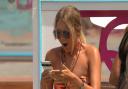 Tasha reading a text. Love Island: Live Final airs tonight at 9pm on ITV2 and ITV Hub. Episodes are available the following morning on BritBox.